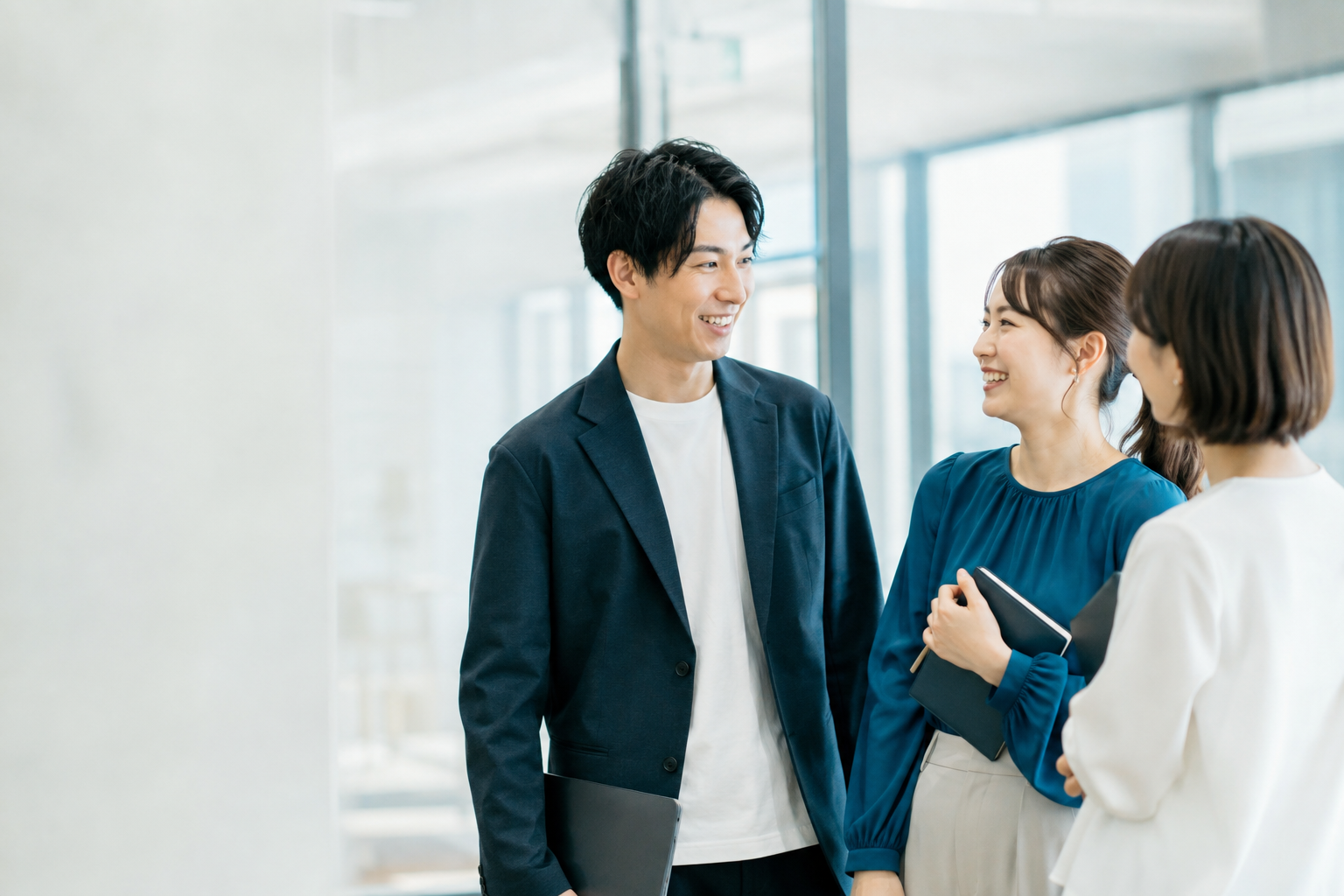 明るいオフィスで対話する社会人のイメージ